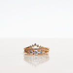 Ring stack with three Mumbaistockholm Fine Jewelry Rings:  Elise Ring in 18K yellow gold with five white, conflict-free diamonds, Jade Petite Wave Half Ring with a curved band half covered with 0.005 CT diamonds TWVS, and Five Diamond Triangle Ring with five 0.02 CT diamonds TWVS.